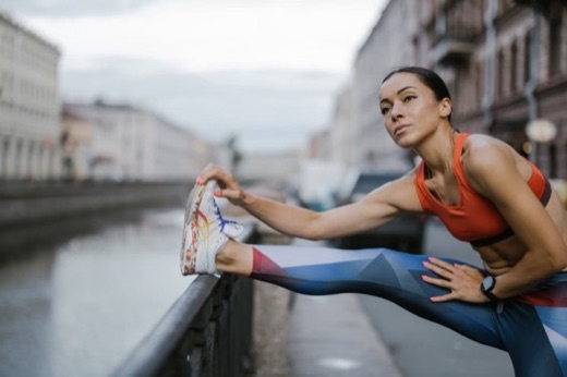 Woman stretching beside an urban canal