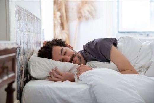 Man sleeping peacefully in a bright bedroom